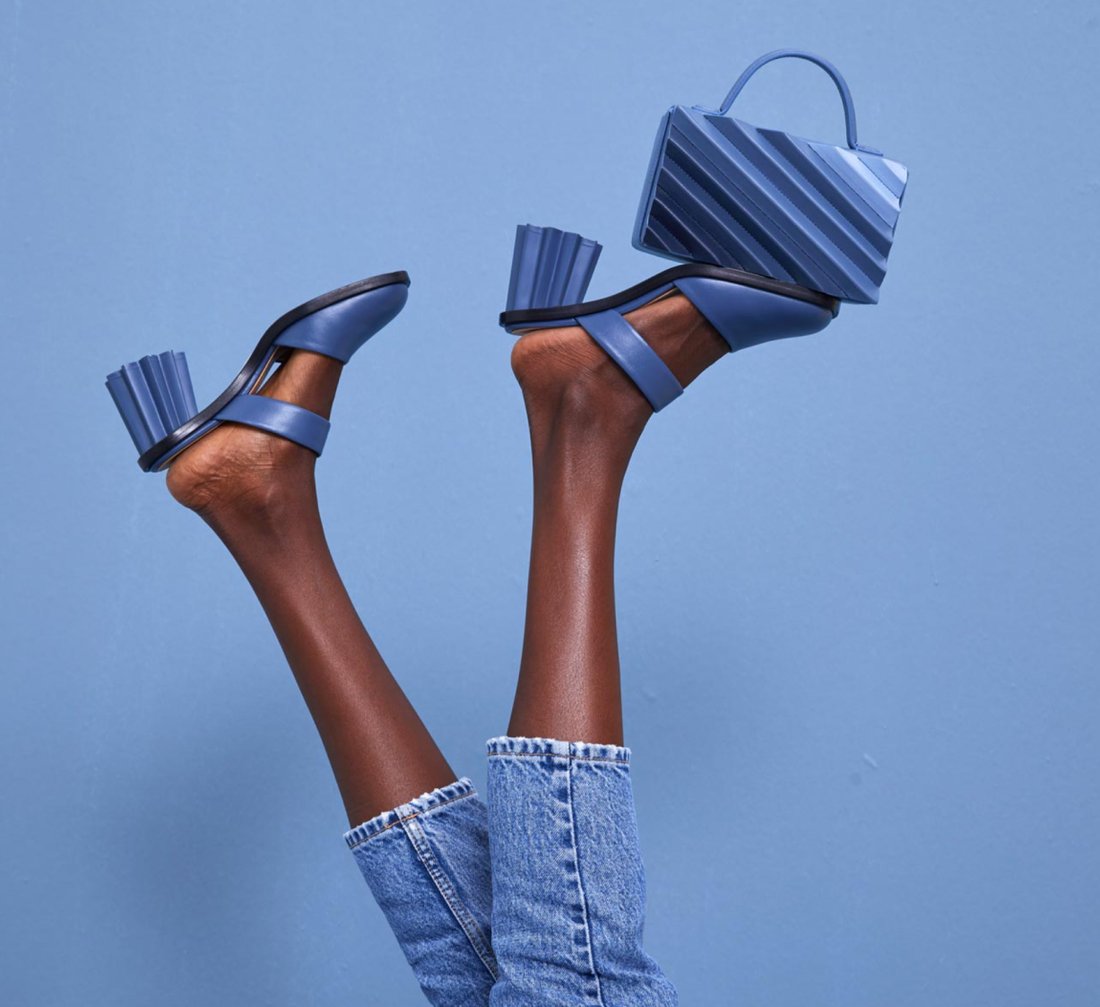 A woman's feet in the air, balancing a blue bag
